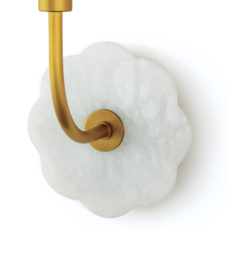 Brass and alabaster wall sconce on white wall.