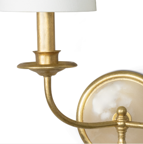 Gold wall sconce on white wall.
