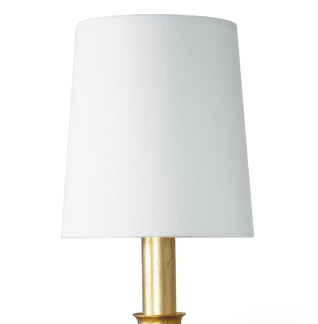 Gold single fisher sconce on white wall with white lamp shade.