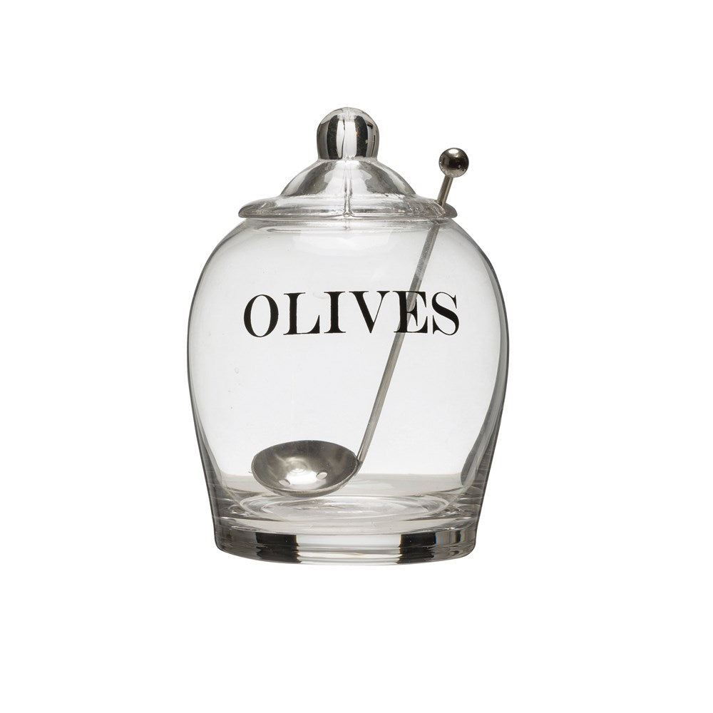 Glass olive jar with spoon on white background