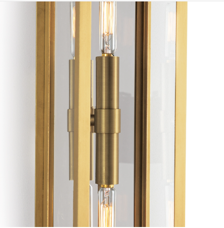 Natural brass sconce with light on white wall.