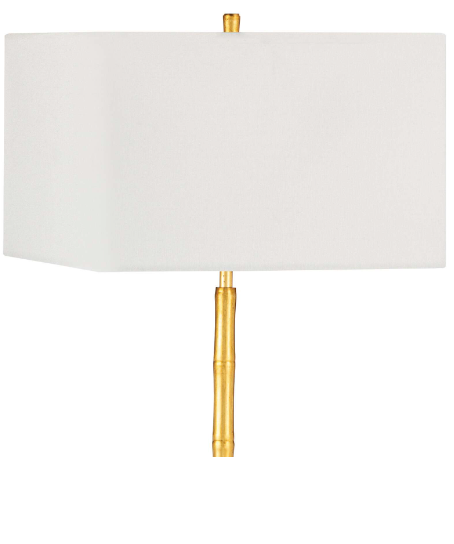 Gold lamp with white lamp shade on white background.