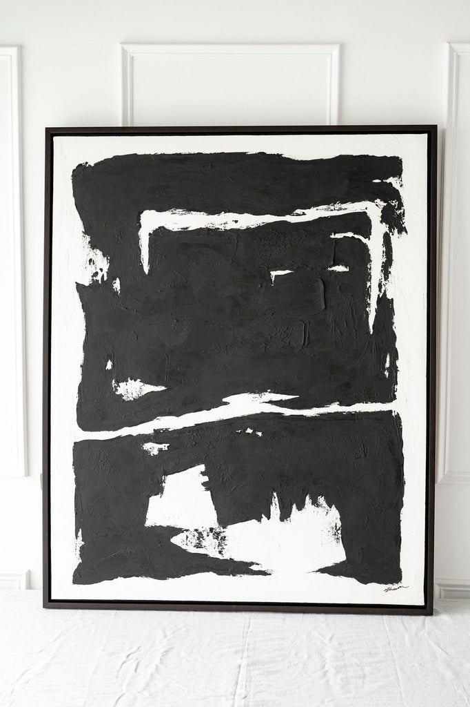 Solo black artwork on table with white wall behind
