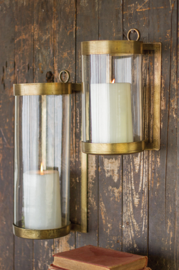 Antique brass wall sconce on wood wall.